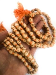 Neem japa mala made from Neem beads, hand knotted on orange cotton thread, and printed in Hindi script with "Radhe Radhe" on each bead. (Printing is not so great; barely legible in some cases, but the thought is there!) The beads are approximately 8mm or 10mm (two sizes) and end with small orange-colored cotton tassel. Choose from two sizes small 7- 8mm beads ($4.50) large 9 - 10mm ($5.50) Spiritual Wooden Beads Mala For Festival, Orange Wooden Beads For Festivals, Hand-strung Orange Beads As A Gift, Orange Wooden Beads For Festival, Holistic Mala With 8mm Beads For Festivals, Bohemian Hand-strung Orange Beads, Traditional Orange Beads For Gifts, Hand-strung Orange Bohemian Beads, Holistic Wooden Beads For Festivals