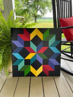 a colorful quilt sitting on top of a wooden deck