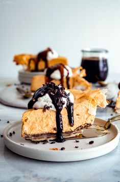 a piece of pie on a plate with chocolate sauce and whipped cream drizzled on top