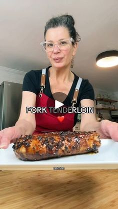 a woman holding up a large piece of meat