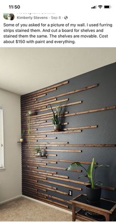 the wall is made out of wood strips and has plants on it, along with a plant