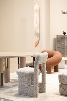 an assortment of modern furniture on display in a room with white walls and carpeted flooring