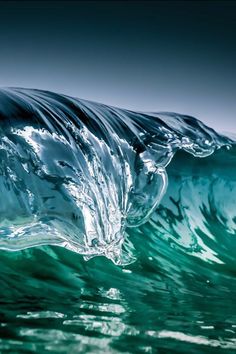 an ocean wave with green and blue colors