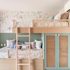 a bunk bed sitting next to a blue door in a room with floral wallpaper