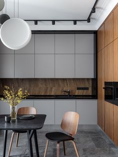 two chairs and a table in a room with wood paneling on the wall behind them