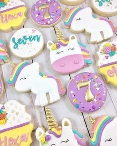 decorated cookies with unicorns, donuts, and other treats on a white table