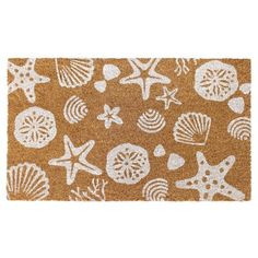 a brown door mat with white sea shells and starfishs on the front side