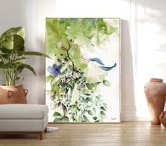 a living room scene with a couch and potted plant on the floor in front of a large painting