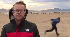 a man with glasses and a hoodie running on the beach in front of another person