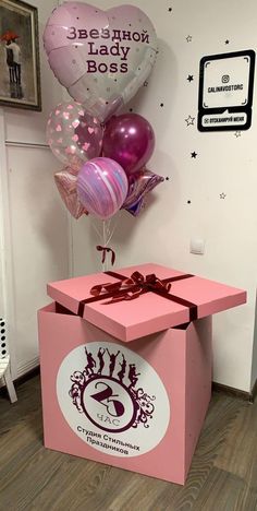 a pink box with some balloons in it