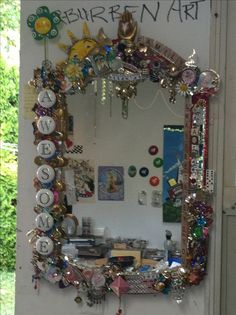 there is a mirror that has been decorated with many things on the wall and around it