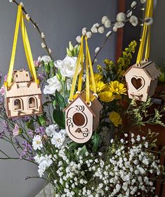 a vase filled with flowers and birdhouses hanging from it's sides