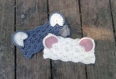 two crocheted hats laying on top of a wooden floor