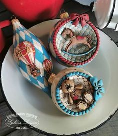 three ceramic ornaments sitting on top of a white plate