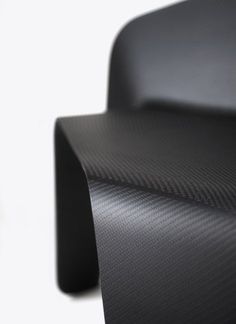 a close up view of the back end of a black chair with carbon fiber on it