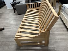 a wooden bench sitting on top of a hard wood floor next to a bed in a living room