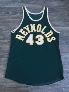 a green and yellow basketball jersey with the number 43 on it sitting on a wooden floor