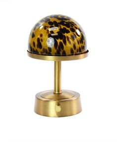 a lamp that is on top of a metal stand with a leopard print shade over it