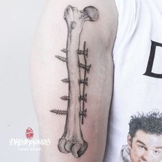 a man with a tattoo on his arm that has a bone and spikes attached to it