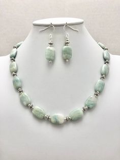 DESCRIPTION:  This beaded necklace features a strand of aquamarine rectangle-shaped beads spaced with tiny round silver pewter beads and tiny silver pewter saucer-shaped beads. I kept the design extremely simple to keep the focus on the aquamarine nuggets. The aquamarine beads are a soft blue color with white inclusions in the stone--it is reminiscent of clouds against a pale blue sky or the white caps on ocean waves! Each bead is so unique and lovely. The tiny silver beads adds a decorative det Aquamarine Round Beads Jewelry With Natural Stones, Elegant Beaded Amazonite Jewelry, Blue Amazonite Jewelry With Polished Beads, Elegant Amazonite Jewelry With Faceted Beads, Elegant Aquamarine Faceted Beads Jewelry, Elegant Aquamarine Jewelry With Faceted Beads, Aquamarine Faceted Beads Jewelry, Single Strand Aquamarine Jewelry Gift, Blue Single Strand Amazonite Jewelry