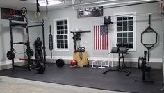 an empty gym room with various exercise equipment and american flag on the wall behind it