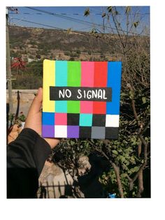 a hand holding up a colorful piece of paper with the words no signal on it