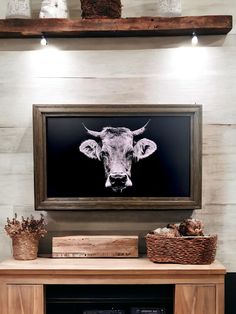 a cow's head is mounted on the wall above a fireplace