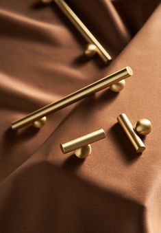 two gold handles on a brown satin surface