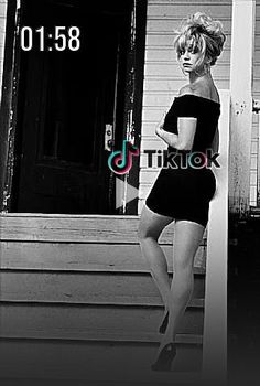 a black and white photo of a woman standing on steps