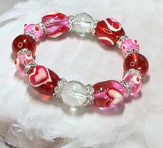 Heart Bracelet, Glass Beaded Bracelet For Women, Pink Red Stackable Bracelet For Valentine Mother's Day, Christmas Birthday Gift Ideas, 1 pc Delicately painting of hearts on colorful glass beads decor' with zircon spacers. One of a kind Valentines design jewelry Approx. 7.5 inches in length thread with strong elastic cords for longer durability that fits most women's wrist.  Exclusive design makes the most beautiful gift for Birthday, Mothers Day, Valentine, Anniversary, Friendship days, Christmas, Graduation, or any happy occasions. ✔️ A BRAND YOU CAN TRUST ✔️ Our Company sells fashion jewelry for more than 3 decades now, we are very reliable and the second generation keeps it going by adding more new trends with hard work and passion. Notes: 1.Devices you are viewing this listing on will Adjustable Crystal Bracelet For Valentine's Day, Adjustable Crystal Bracelet With Heart Beads For Gift, Adjustable Heart Beads Crystal Bracelet Gift, Adjustable Heart-shaped Crystal Bracelet Gift, Handmade Adjustable Crystal Bracelet For Valentine's Day, Valentine's Day Party Bracelets, Pink Heart Bracelet For Valentine's Day Party, Heart Shaped Bangle For Valentine's Day Party, Pink Heart-shaped Beaded Bracelets For Party