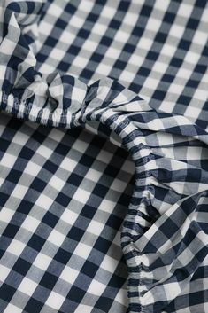 a close up view of a blue and white checkered shirt with ruffles