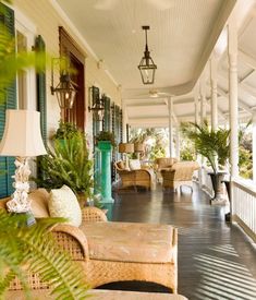 a porch with wicker furniture and green plants