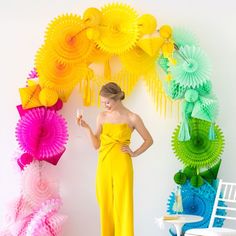 a woman standing in front of colorful paper decorations