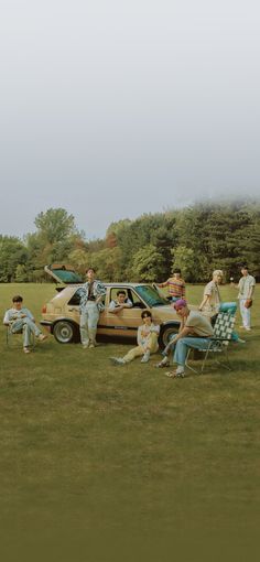 a group of people sitting in lawn chairs next to a car