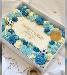 a soccer themed birthday cake in a gift box with a gold medal on the top