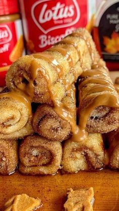 cinnamon rolls are stacked on top of each other with caramel sauce in the background