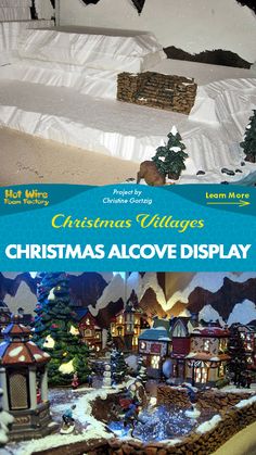 the christmas village is set up in front of a snow covered bed and mountain scene