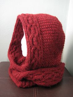 a red knitted hat sitting on top of a table