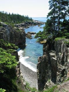 an ocean view with rocks and trees on the shore