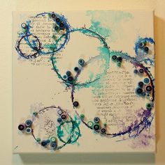 an art piece with blue and purple circles on it's canvas, hanging on the wall