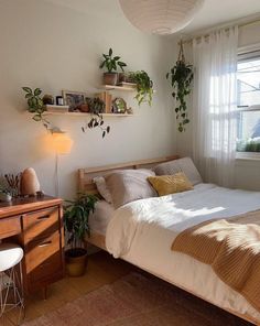 a bed room with a neatly made bed next to a window and a mirror on the wall