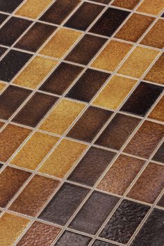 a close up view of a brown and black tile floor with different colors on it