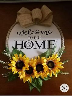 a welcome sign with three sunflowers in front of it that says welcome to our home