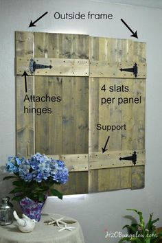 a wooden pallet wall with instructions to attach the boards and brackets on it, along with a vase filled with blue hydrangeas