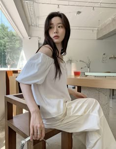 a woman sitting on top of a wooden chair