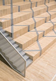 an escalator with wooden steps leading up to the second floor in a building