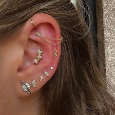 a close up of a person's ear with multiple piercings on top of it