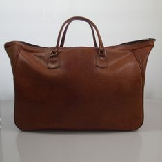 Vintage brown imitation leather sportsbag / weekend bag from the 70s In good condition 2 front pockets Sizes H xW x D ± 35 x 51 x 21 cm Classic Brown Weekender Bag For Trips, Brown Leather Tote Travel Bag, Brown Briefcase For Overnight Trips, Brown Satchel Weekender Bag For Daily Use, Brown Satchel With Leather Handles For Weekend Trips, Brown Satchel Travel Bag With Leather Handles, Retro Brown Travel Bag For Everyday Use, Brown Leather Satchel Weekender Bag, Brown Satchel Travel Bag With Luggage Sleeve