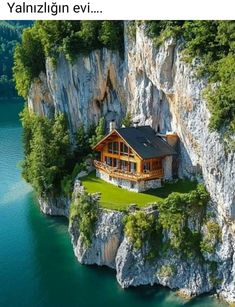 an aerial view of a house on the edge of a cliff in front of water