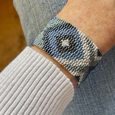 a close up of a person's wrist wearing a bracelet with an evil eye on it